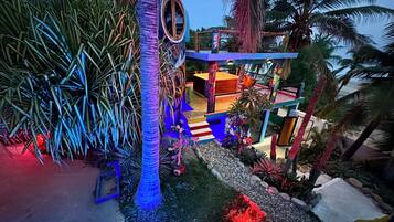 A multi-level outdoor area with a pool, palm trees, and a staircase.