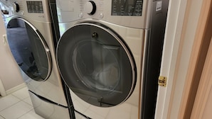 A row of front-loading washing machines in a laundry room with tiled flooring. - Cheery 4 Bedroom Pool Villa (Valrico)