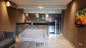 A modern living room with a sofa, coffee table, and a TV mounted on the wall. - Torque 111 (Marrakech)