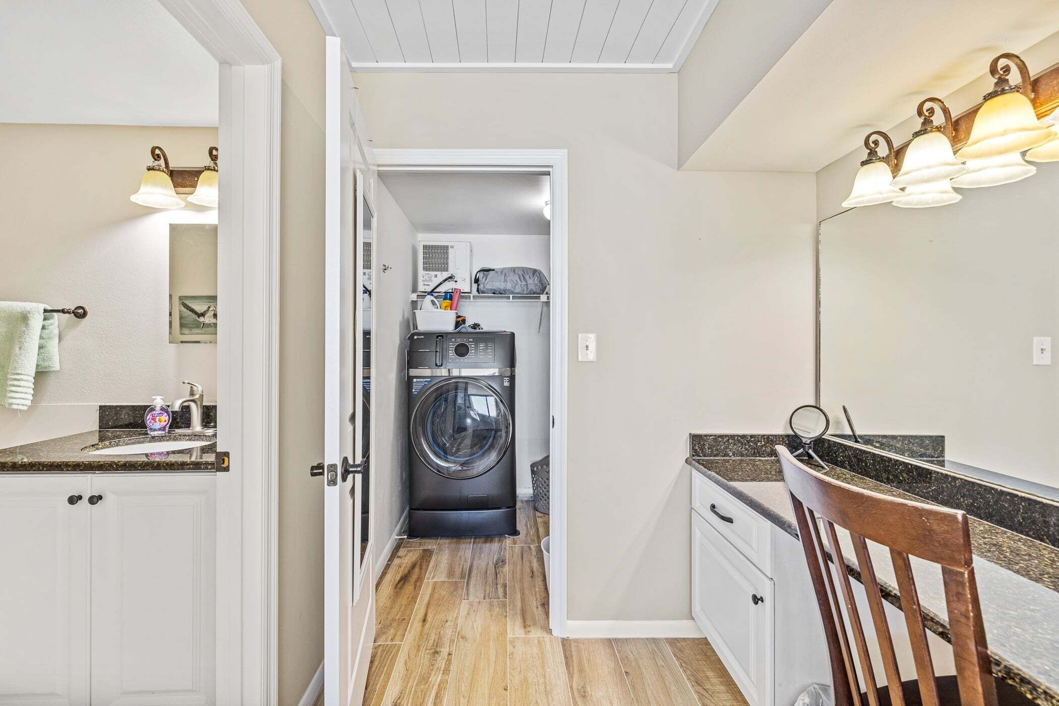 A compact laundry room with a washing machine, a dryer, and a countertop with a sink and storage.