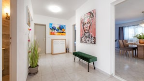A modern interior with a green bench, a potted plant, and artwork on the walls. - Villa Silente (Oklaj)