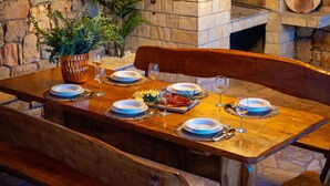 A wooden dining table set with plates, glasses, and a centerpiece. - Villa Silente (Oklaj)