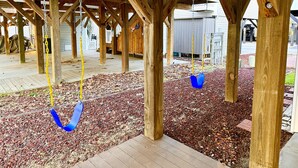 A covered wooden deck with swings and a wooden floor. - Vacation home in Ocean lakes at Myrtle beach (Myrtle Beach)
