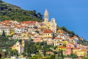 Un pueblo en una ladera con edificios históricos, una iglesia destacada y un campanario.