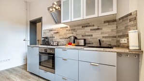 Una cocina moderna con horno integrado, microondas y cafetera.