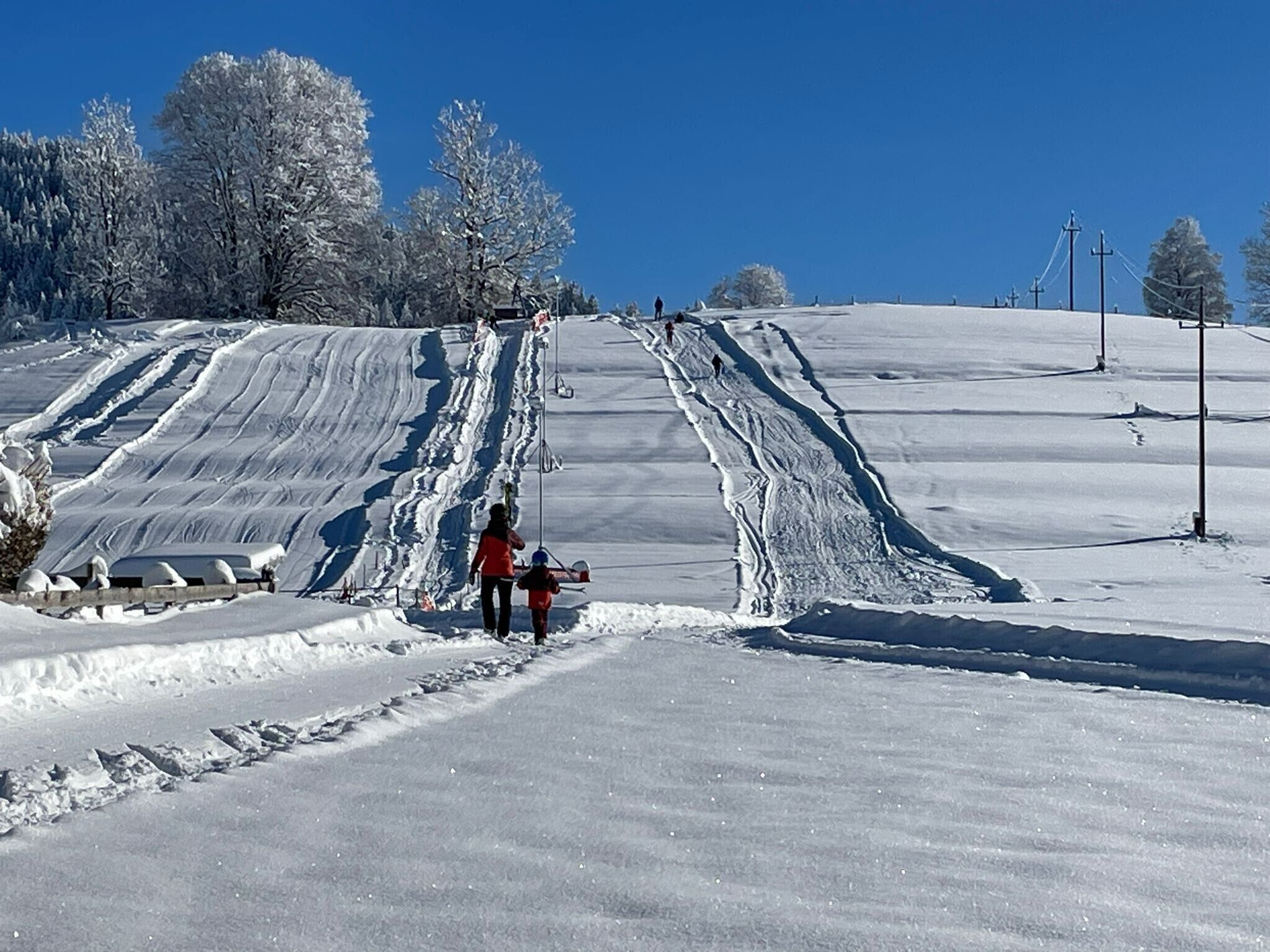 A snowy ski slope with a clear sky.