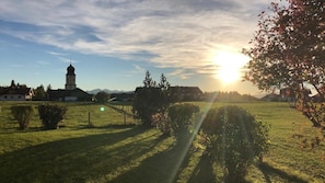 Een landelijk landschap met een kerk, open velden en een heldere lucht.