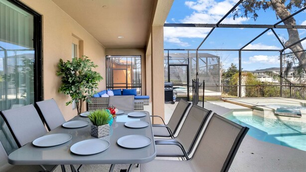 Une terrasse extérieure avec une piscine, un espace salon et un barbecue.
