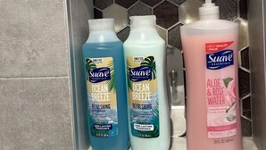 A bathroom shelf with three bottles of Suave Essentials products: two bottles of Ocean Breeze shampoo and conditioner, and one bottle of Aloe & Rose Water. - Luxury 2 bedroom 🛌 Next to UBS Arena🏟 & JFK✈️ (Valley Stream)