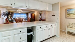 A spacious kitchen with white cabinetry, a large island, and a view of the ocean. - Ocean view from the master bedroom and living room with a spacious balcony (Fernandina Beach)