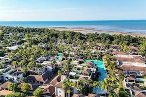 A resort with multiple bungalow-style accommodations, a central pool, and a beach view. - Resort-style Swim Out: A Poolside Oasis (Port Douglas)