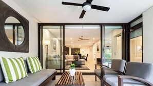 A modern living room with a sofa, armchairs, a coffee table, and a ceiling fan. - The Plunge Pool Residence—Private Resort Living (Port Douglas)