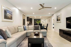 A modern living room with a sofa, coffee table, and TV stand.