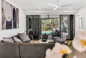 A modern living room with a sofa, coffee table, and artwork on the wall.