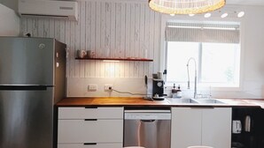 Une cuisine moderne équipée d’un réfrigérateur en acier inoxydable, d’un lave-vaisselle et d’une machine à café.