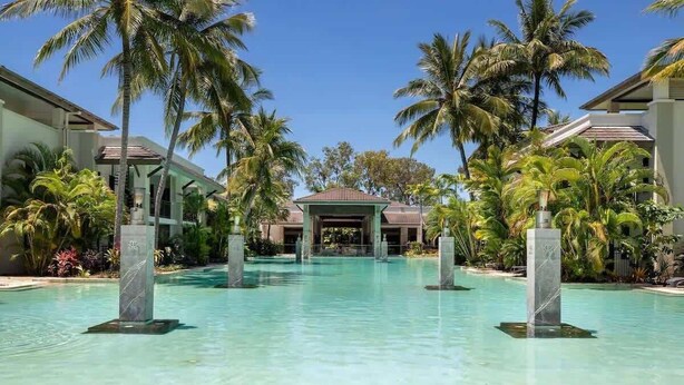A resort pool with palm trees, a covered area, and a building in the background. - Rooftop Resort Oasis at Temple with Spa (Craiglie)