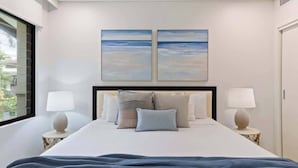 A hotel room with a large bed, two wall-mounted paintings, two bedside lamps, and a window with a view. - Rooftop Resort Oasis at Temple with Spa (Craiglie)