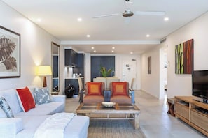 A modern living room with a sofa, coffee table, and TV stand.