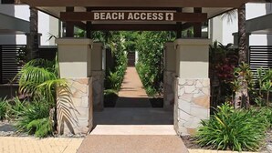 A gated entrance labeled 'BEACH ACCESS' with a pathway leading to a beach. - Devine Rooftop Penthouse at Temple Resort (Port Douglas)