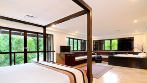 A modern bedroom with a large bed, a desk, a sofa, and a large mirror. - The Villa at Temple: A Luxury Resort Hideaway (Port Douglas)
