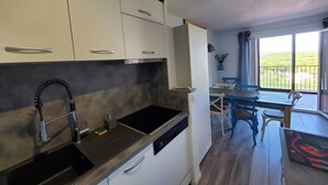 Een moderne keuken met een ingebouwde vaatwasser en een eetgedeelte met uitzicht op de omgeving.