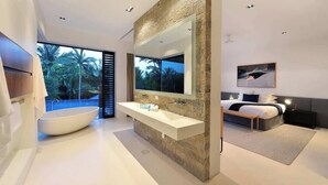 A modern bathroom with a freestanding bathtub, a large mirror, and a double sink.