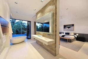 Un bagno moderno con una vasca freestanding, un grande specchio e un doppio lavabo.