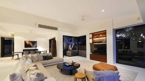 A modern living room with a sectional sofa, a coffee table, and a seating area with a bench.