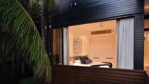 A bedroom with a bed, a nightstand, and a painting on the wall.