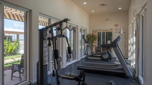 A gym with cardio equipment, weight machines, and a treadmill. - Casual Condo Near Beach w/ Pools, hot tub & Grill! (South Padre Island)