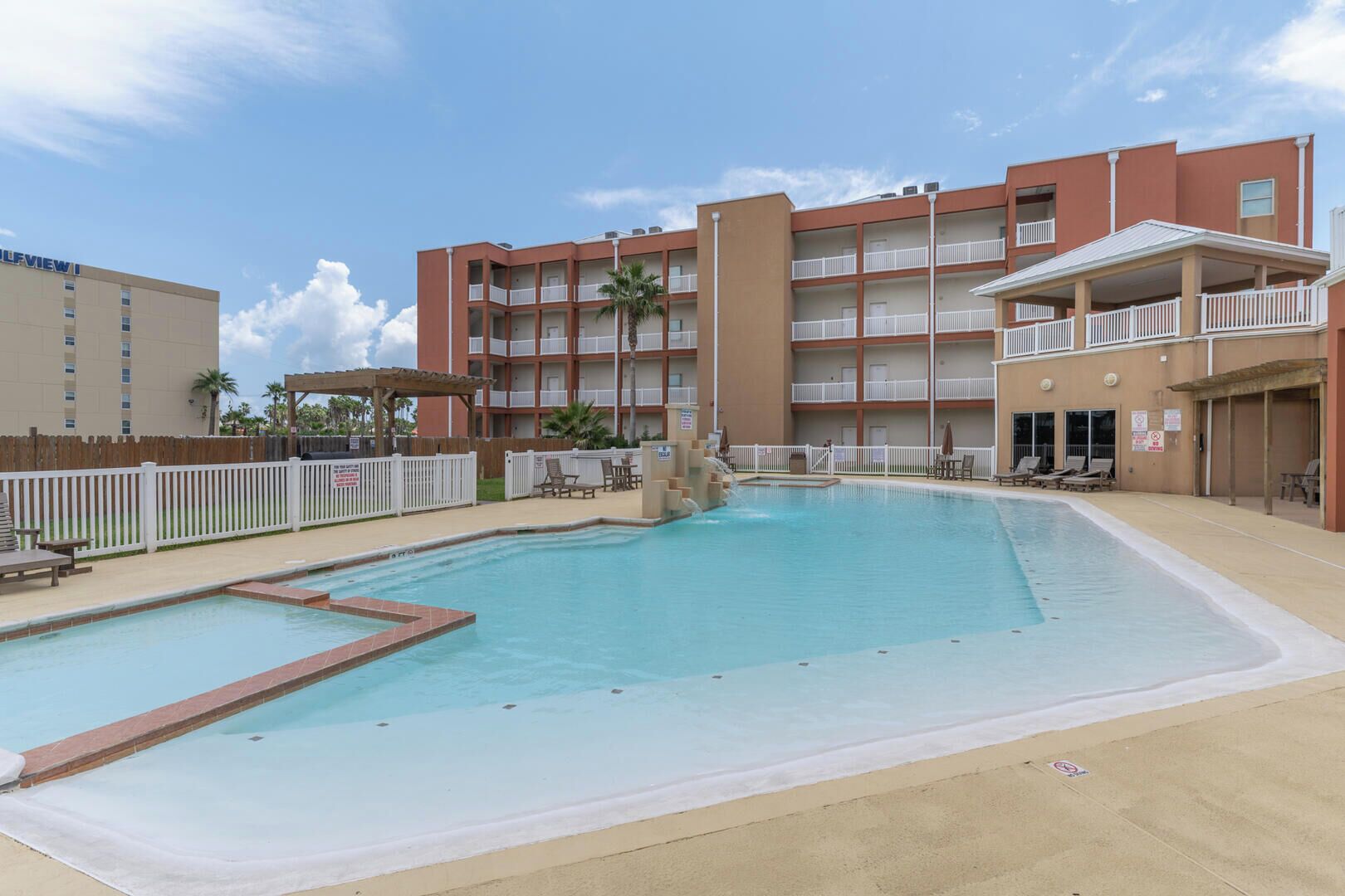 Un hôtel doté d’une piscine, d’un espace extérieur aménagé et d’un bâtiment à plusieurs étages avec des balcons.