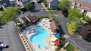 Ein Luftbild eines Wohngebiets mit Swimmingpool, Liegestühlen und einem kleinen Gebäude.