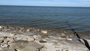 Eine felsige Küstenlinie mit klarem Wasser und blauem Himmel.