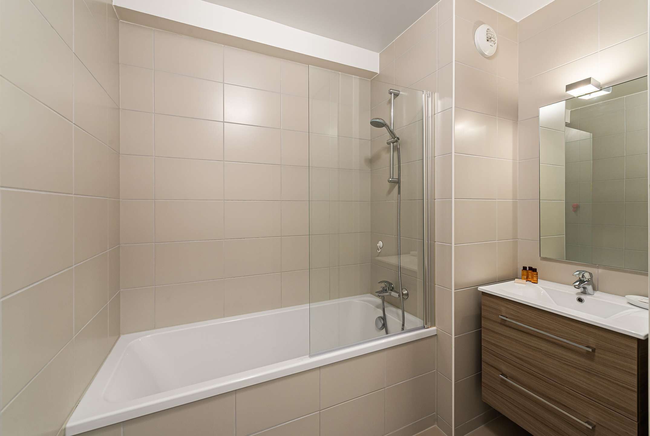 Ein modernes Badezimmer mit Badewanne, Dusche und Waschtisch mit Spiegel.