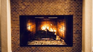 A fireplace with a brick surround and a mantel above it. - ESCAPE THE MADNESS with no better place to relax!  NEW LUXURY SPA AND HUGE POOL! (North Las Vegas)
