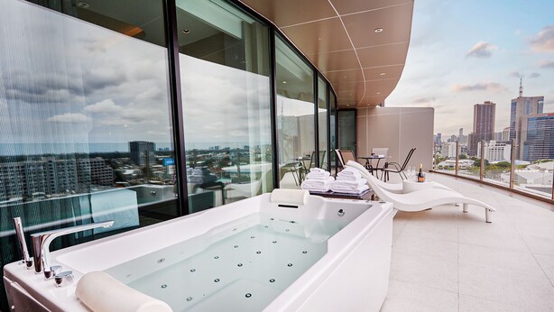 A modern spa area with a large bathtub, a glass-enclosed balcony, and a city view. - Valia Bangkok Sukhumvit 24 by Kingston Hotels (Bangkok)