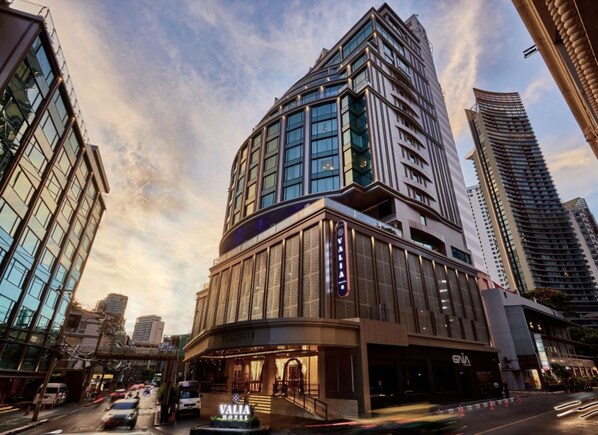 A modern hotel with a prominent corner location, large windows, and a well-lit entrance. - Valia Bangkok Sukhumvit 24 by Kingston Hotels (Bangkok)