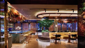 A modern hotel lobby with a bar area, seating arrangements, and a central plant. - Valia Bangkok Sukhumvit 24 by Kingston Hotels (Bangkok)