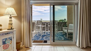 Una stanza con vista su un balcone, una lampada e un mobile decorativo.