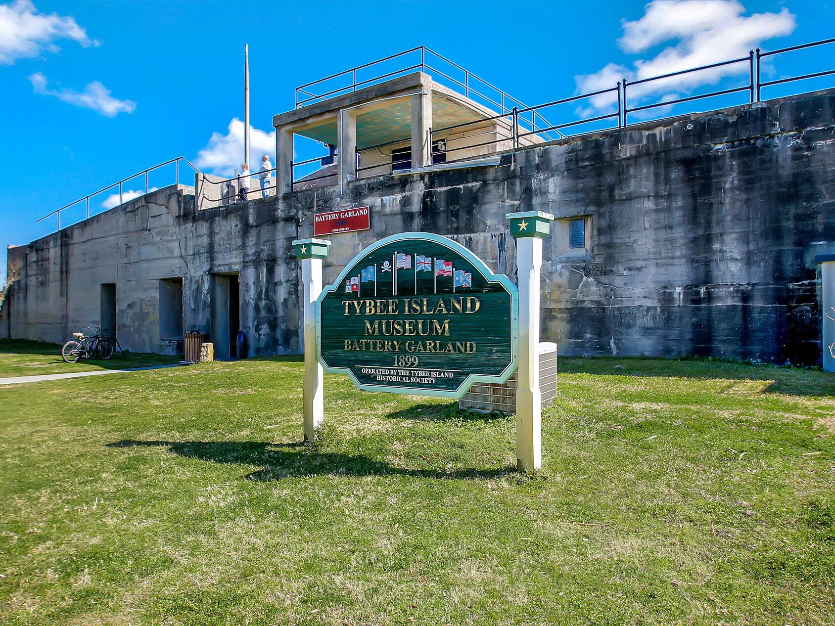 Une enseigne indiquant le musée de Tybee Island, avec un bâtiment historique en arrière-plan.