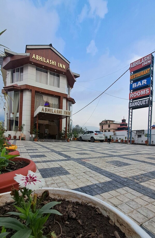 The exterior of Abhilashi Inn with a signboard indicating a restaurant, bar, rooms, and banquet facilities. - ABHILASHI INN (Balh)