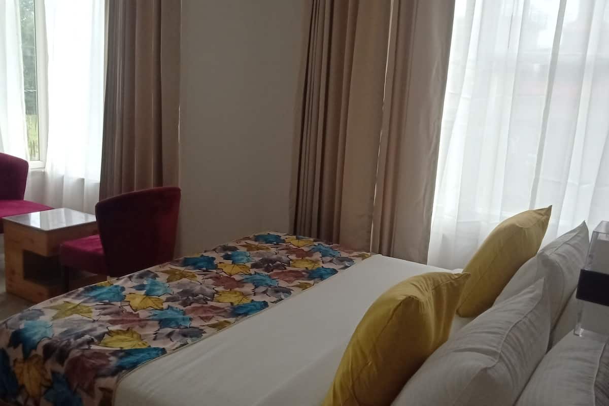 Una habitación de hotel con cama, escritorio, silla y sofá.
