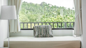 Un balcon avec un lit, un oreiller et une lampe.