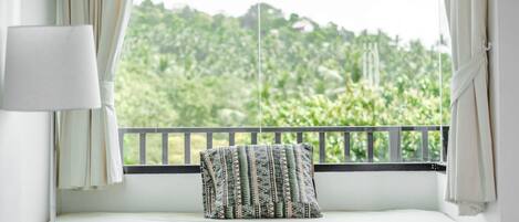 Un balcon avec un lit, un oreiller et une lampe.