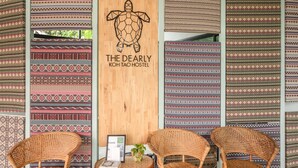 L’intérieur d’une auberge de jeunesse, avec des textiles à motifs, une enseigne en bois ornée d’un logo représentant une tortue, et des meubles en osier.