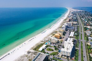 An aerial view of a coastal area with a beach, buildings, and a road. - Snowbird Friendly Rates- Gulf Front Studio | Private Beach Access |Cabana |Access to Sundrift Pool (Fort Walton Beach)