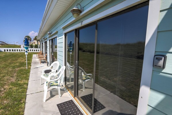 A covered outdoor seating area with chairs and a flagpole. - Snowbird Friendly Rates- Gulf Front Studio | Private Beach Access |Cabana |Access to Sundrift Pool (Fort Walton Beach)