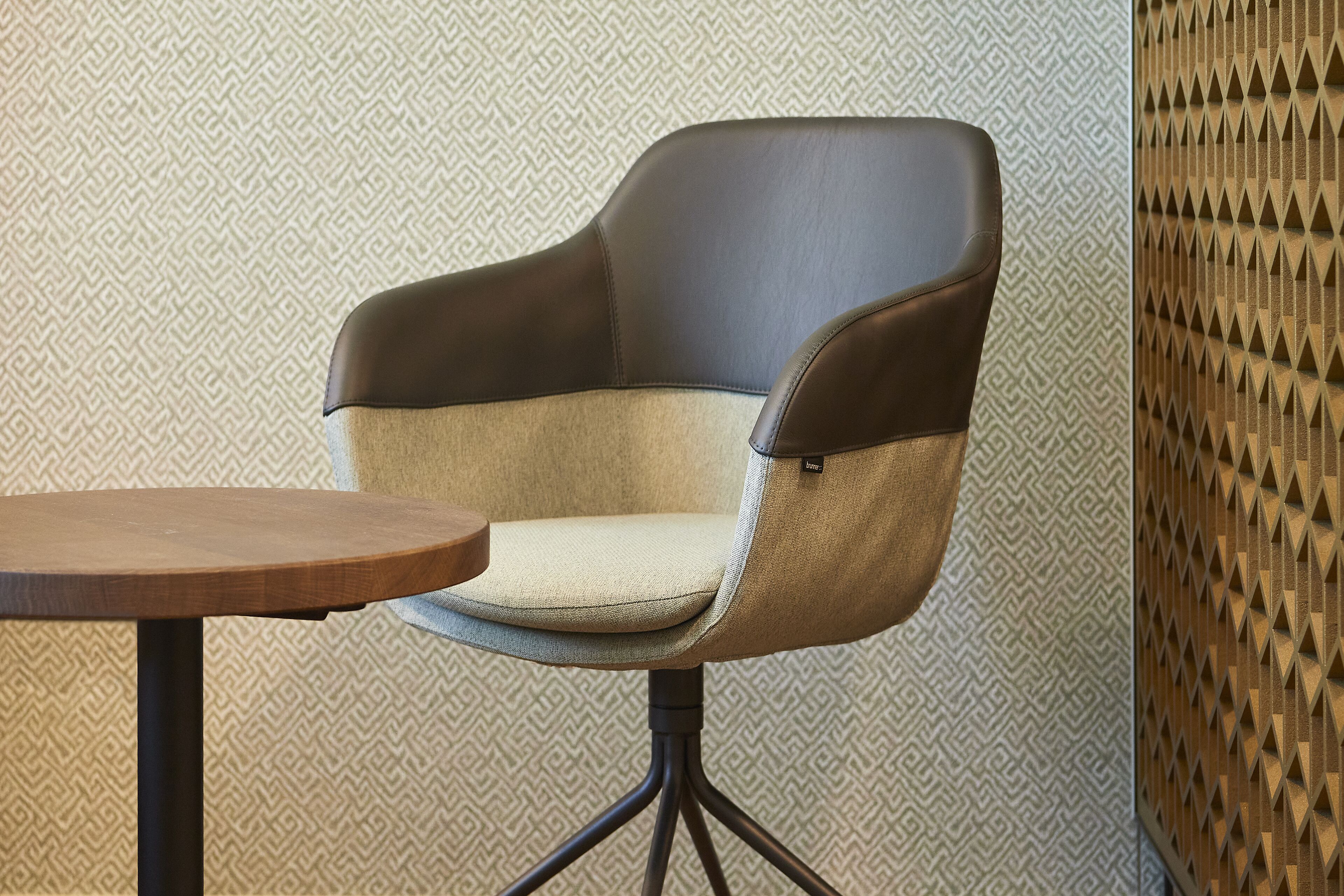 A modern chair with a cushioned seat and backrest, paired with a small wooden table.