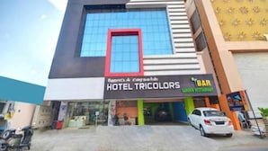 A hotel named "Hotel Tricolor" with a modern facade, a prominent red frame window, and a visible entrance. - PPH Living Tricolours (Coimbatore)