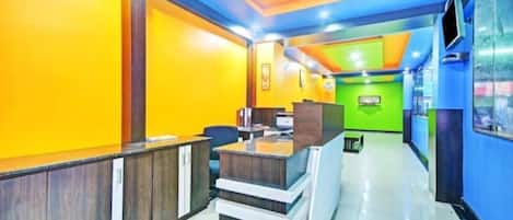 A brightly colored reception area with a counter, chairs, and a desk.